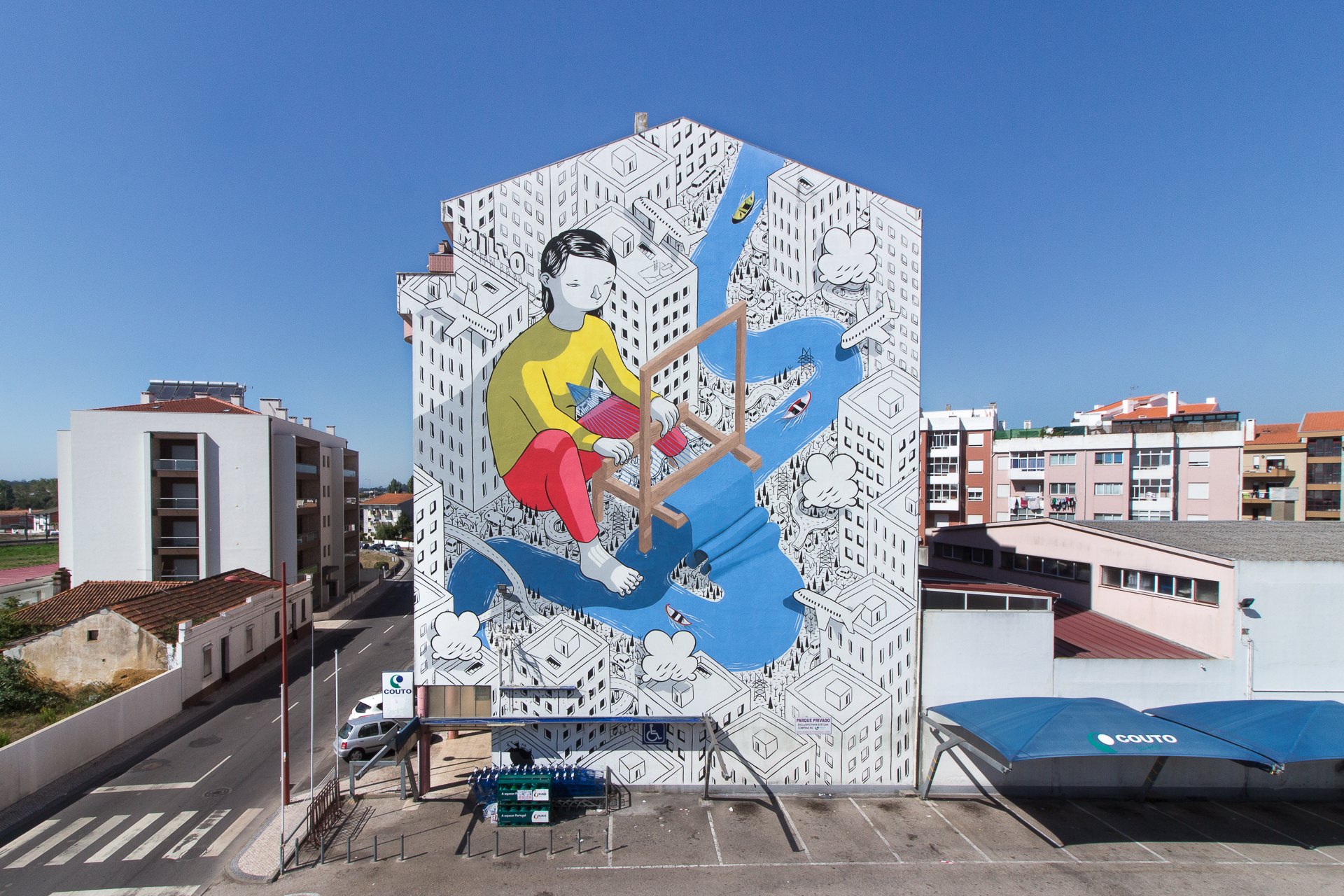 A vast black and white mural covering the end of an apartment block